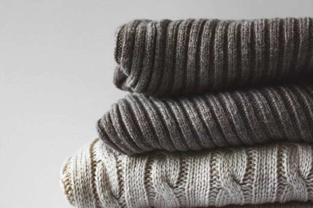 Stos złożonych, szarych swetrów