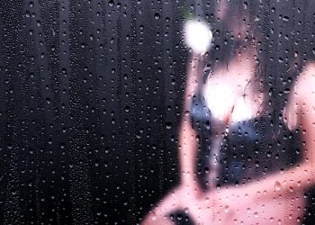 kobieta w czarnym gorsecie za szybą