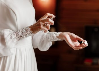 Kobieta psikająca perfumami swój nadgarstek
